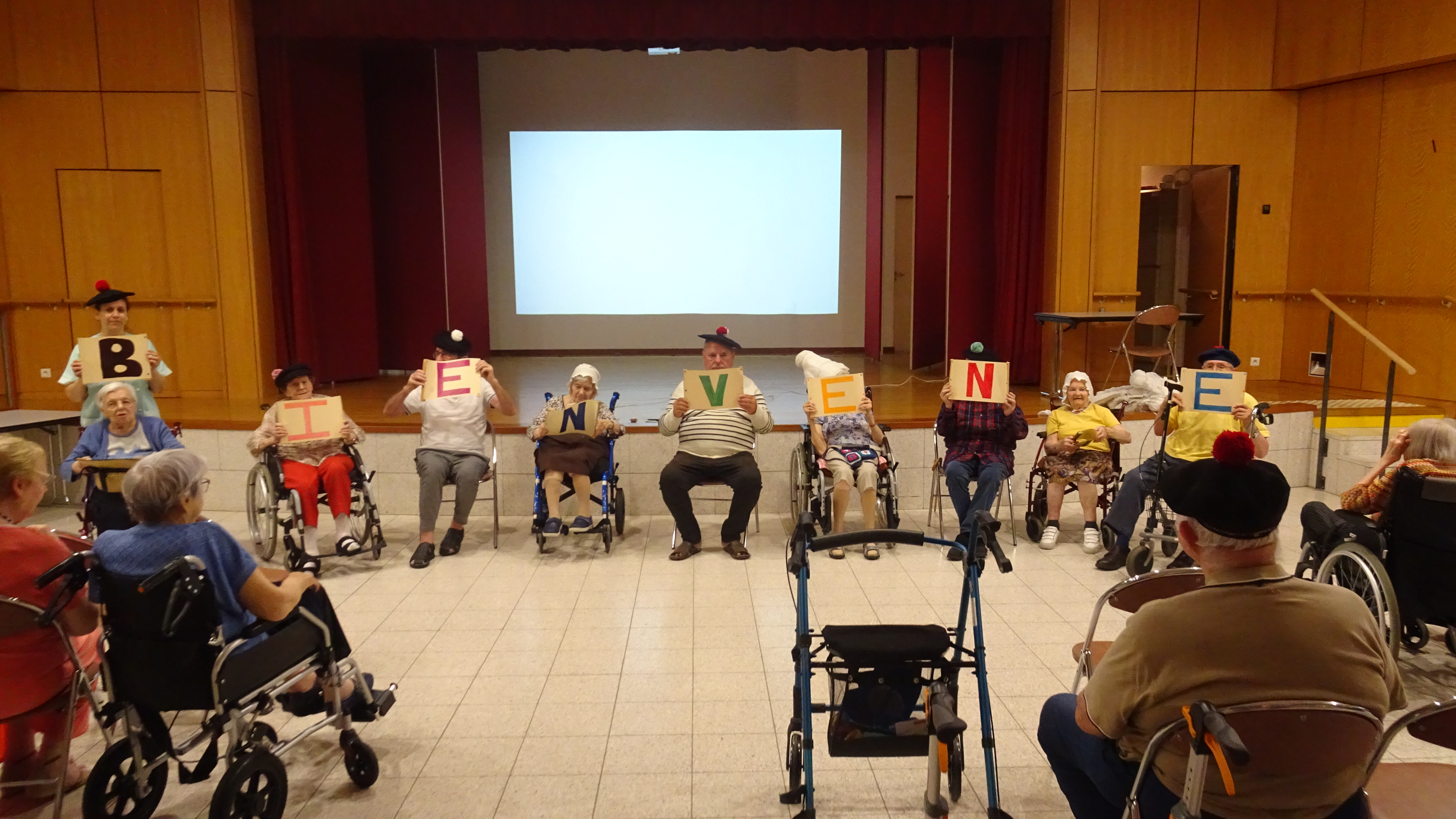 Personnes âgées dans une salle qui tiennent des affiches de bienvenue