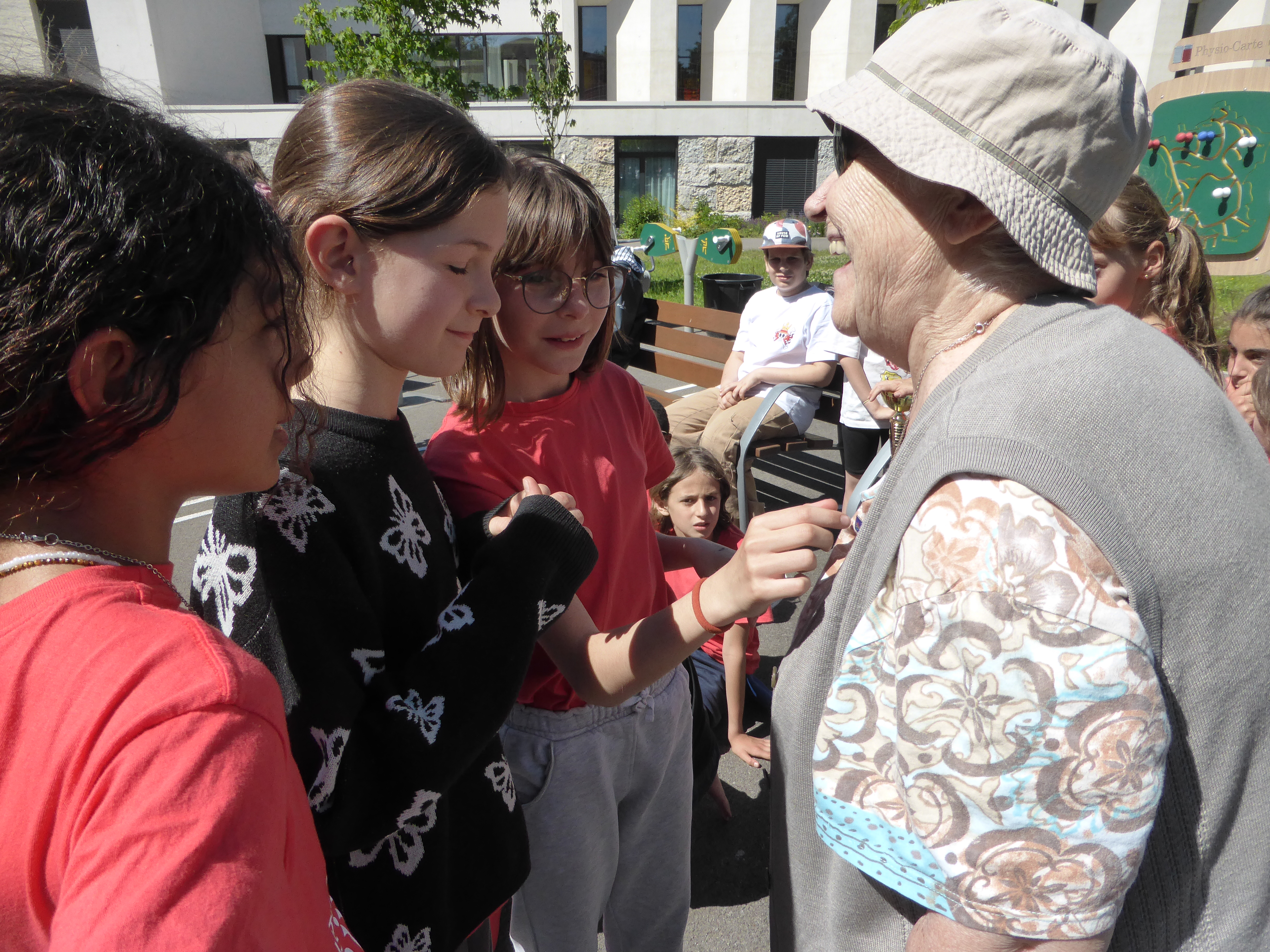 3 petites filles et une personne âgée qui sourient dehors