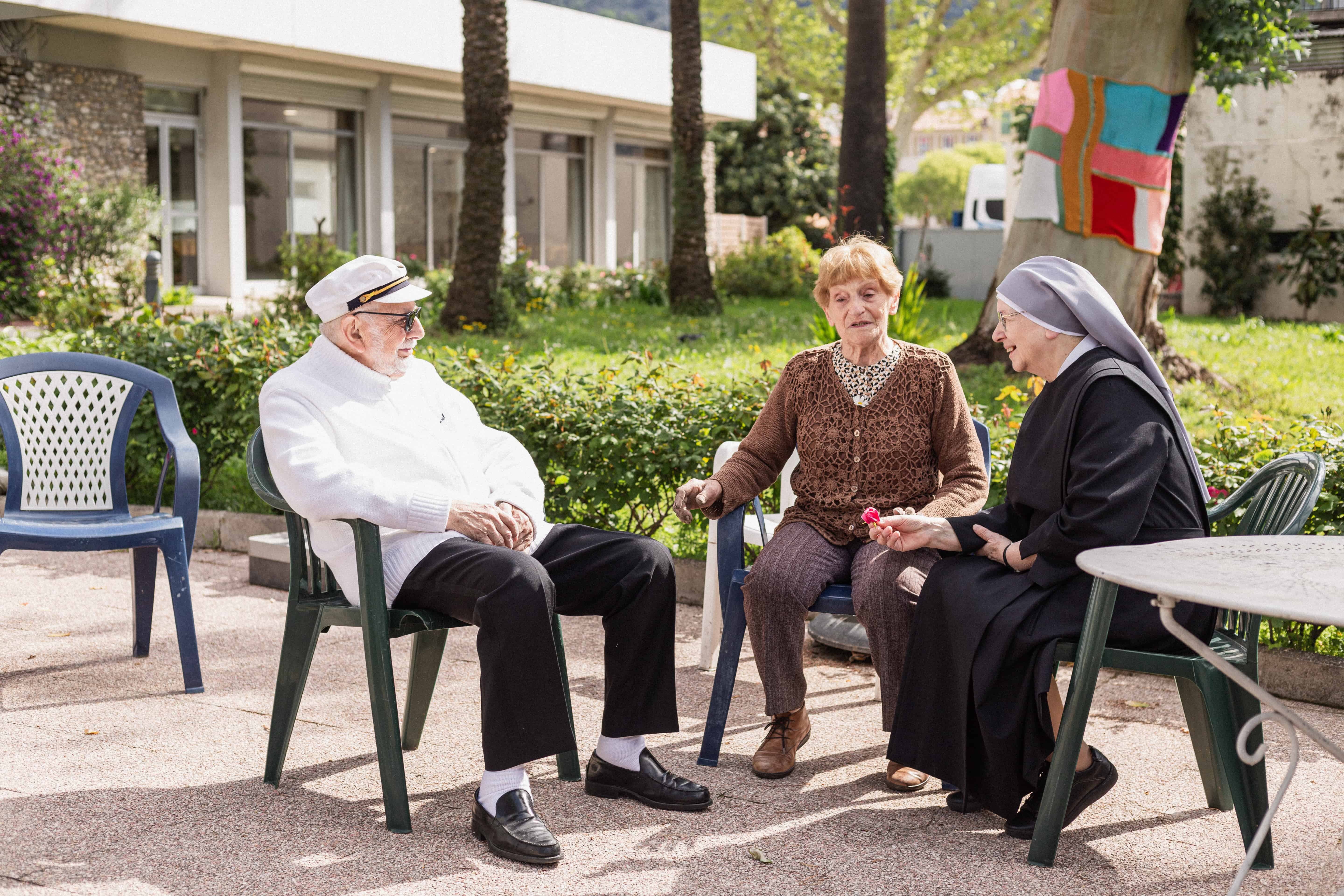 Personnes âgées et petite sœur qui discutent sur un banc