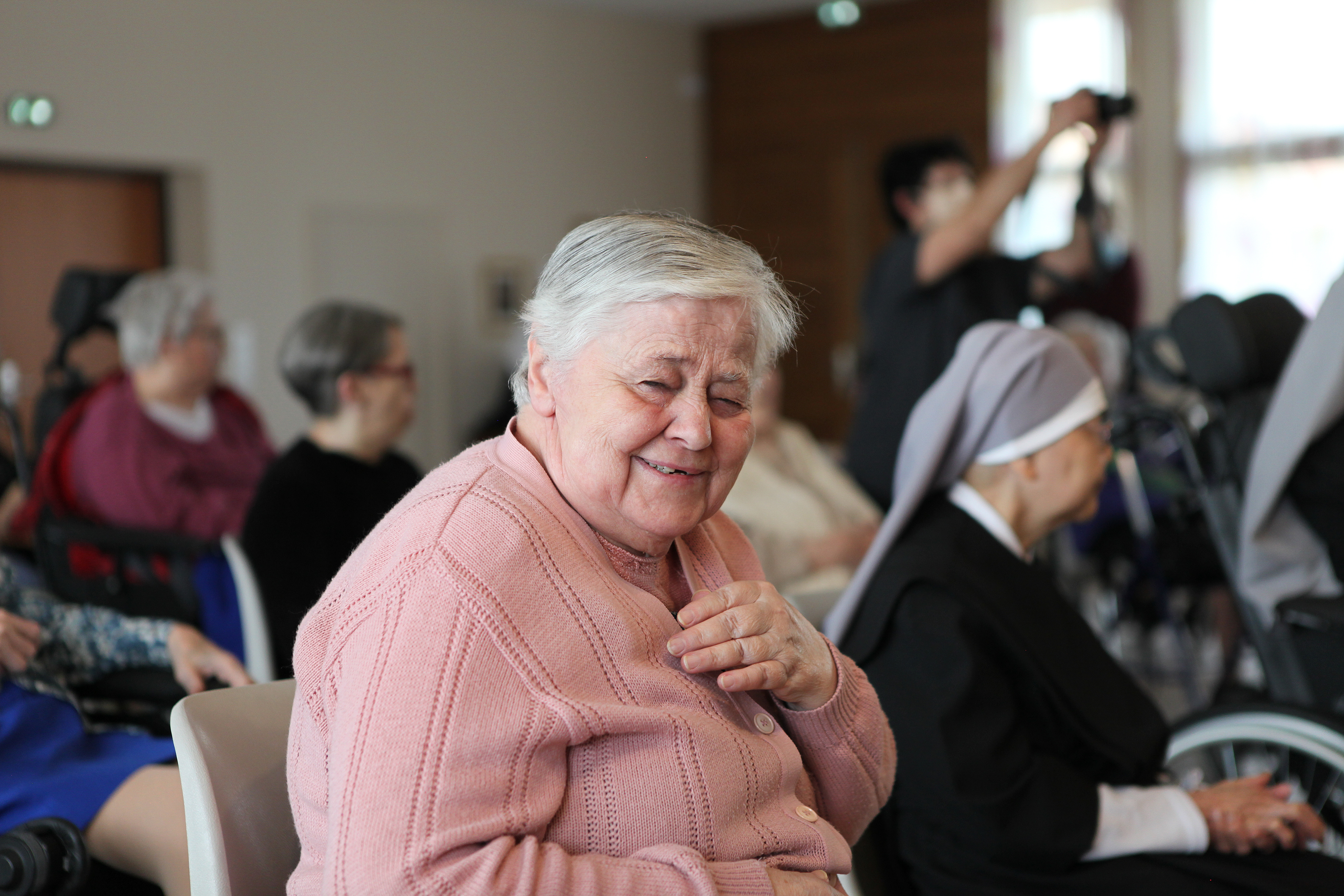 Personne âgée dans une grande salle qui sourit