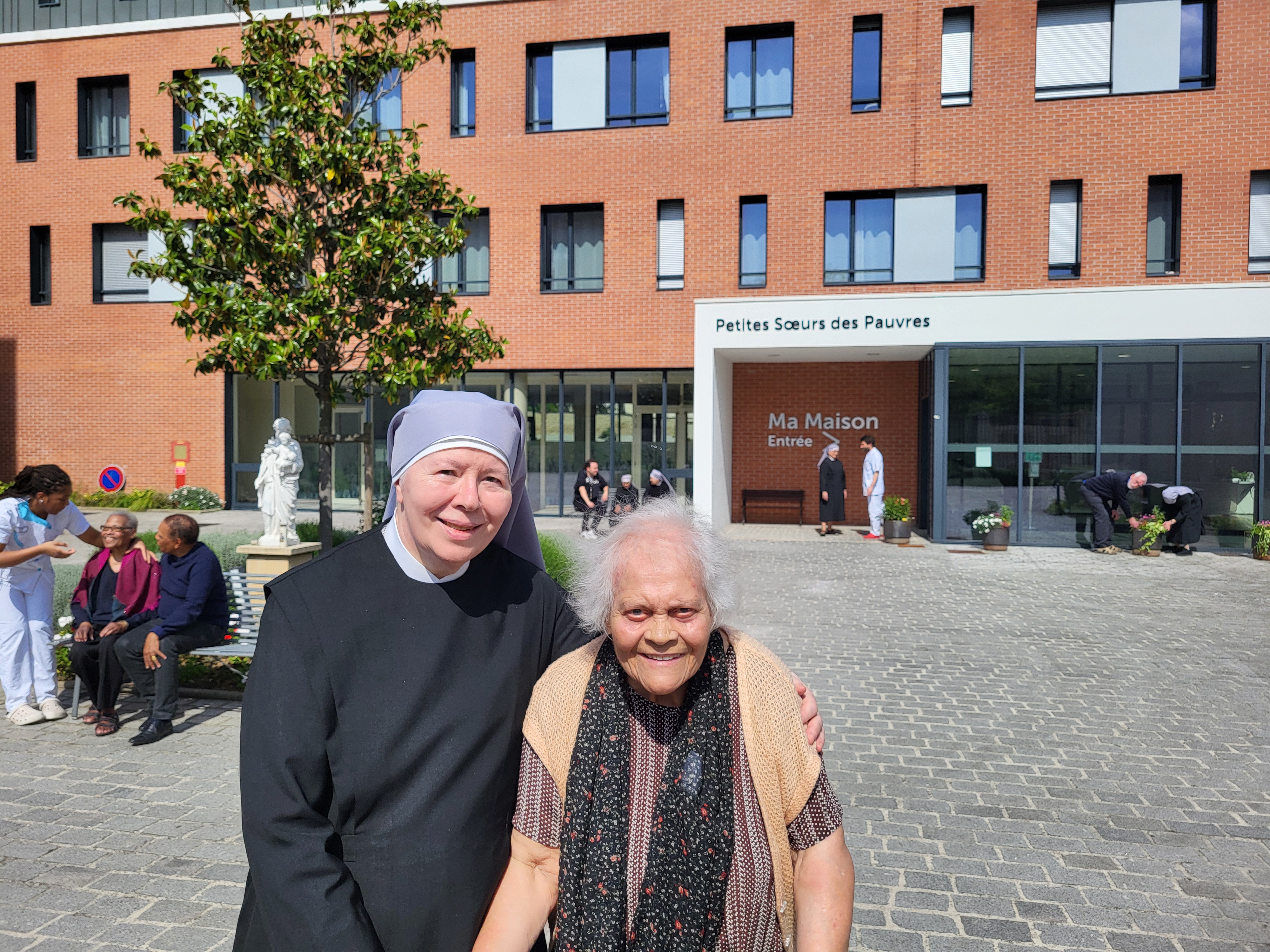 Petite soeur et personne âgée devant une Maison de retraite