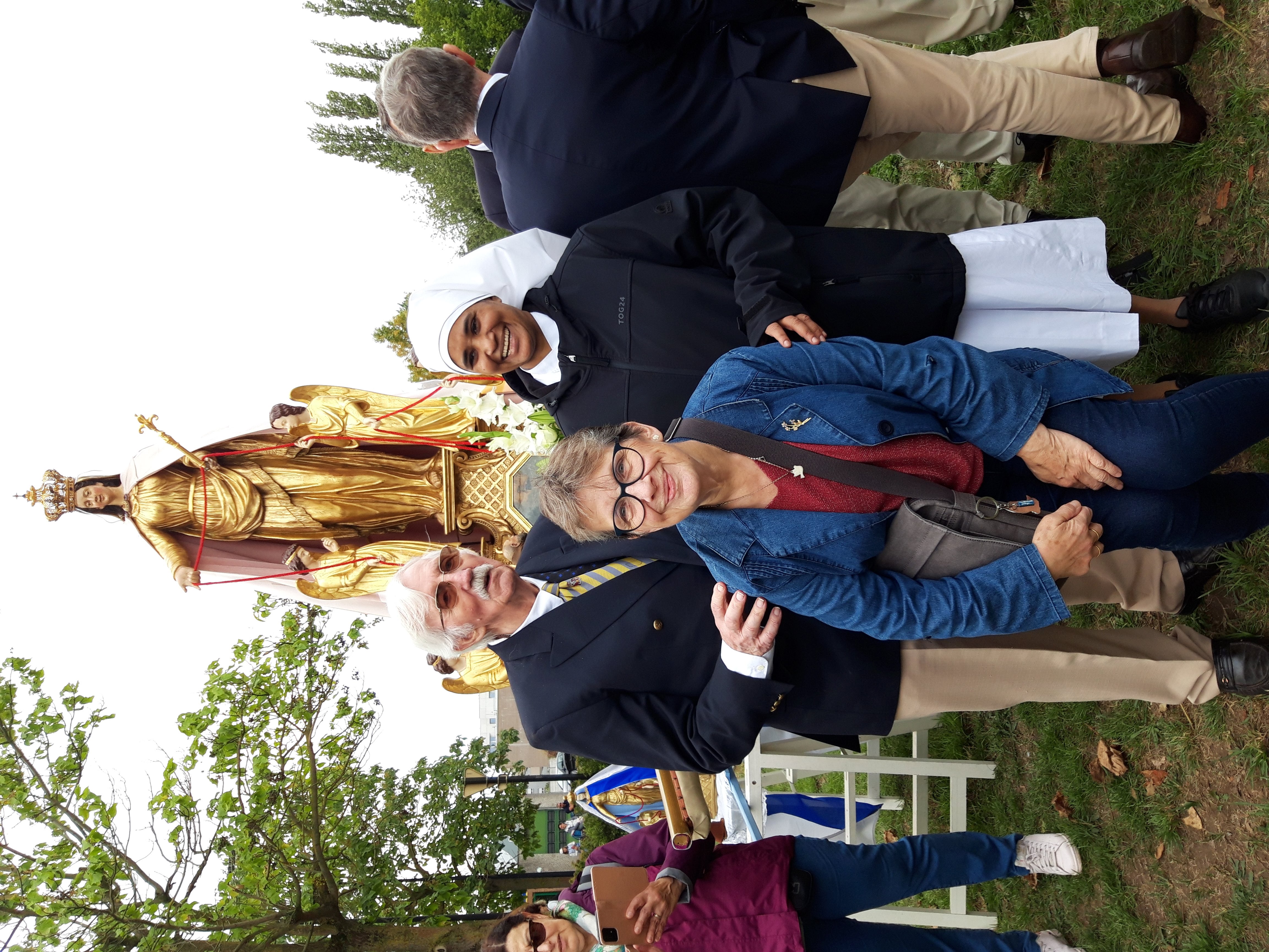 Personnes âgées et petite soeur devant Notre Dame du Cordon