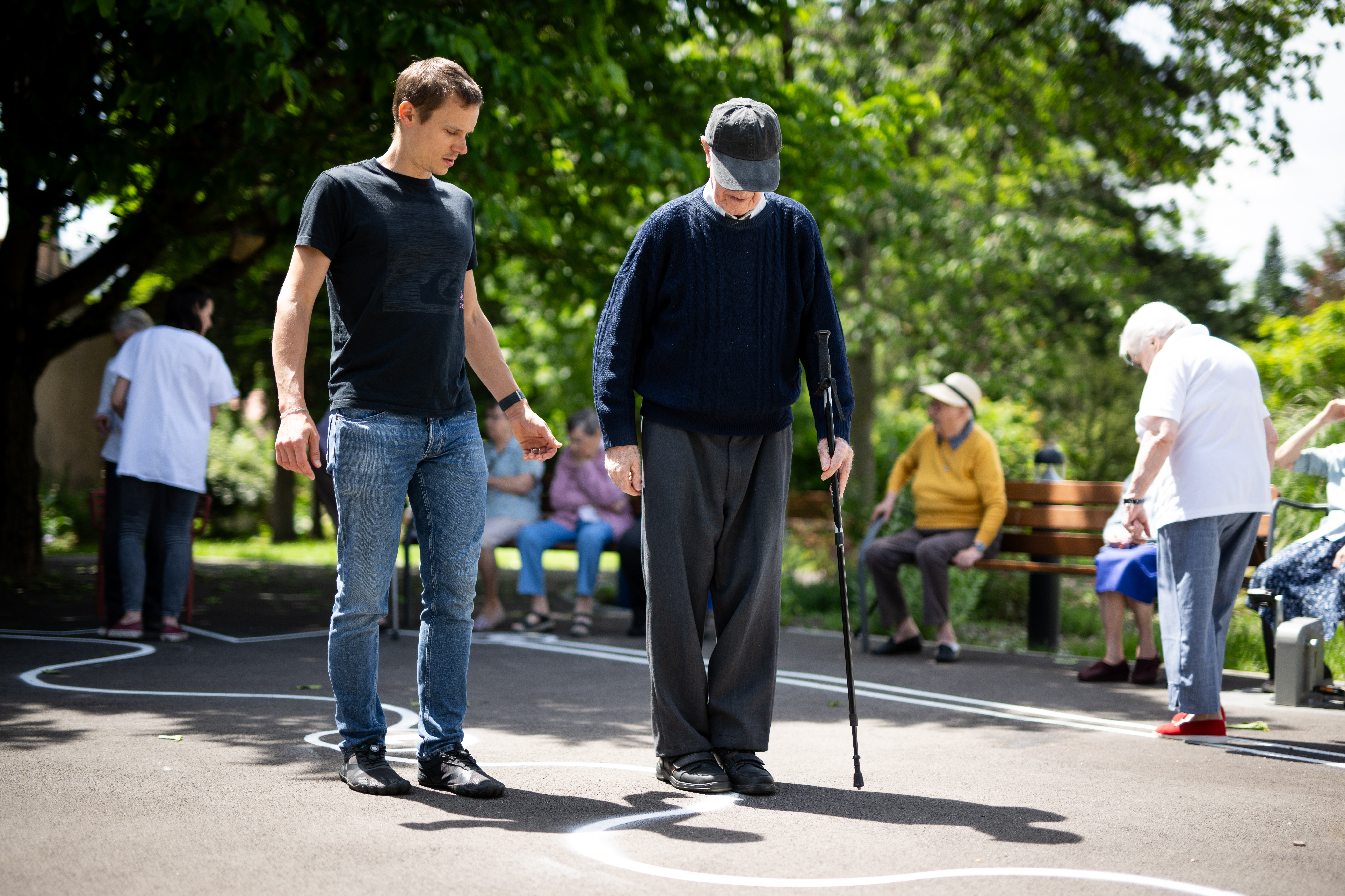 Personne âgée et bénévole qui marche dans une cour