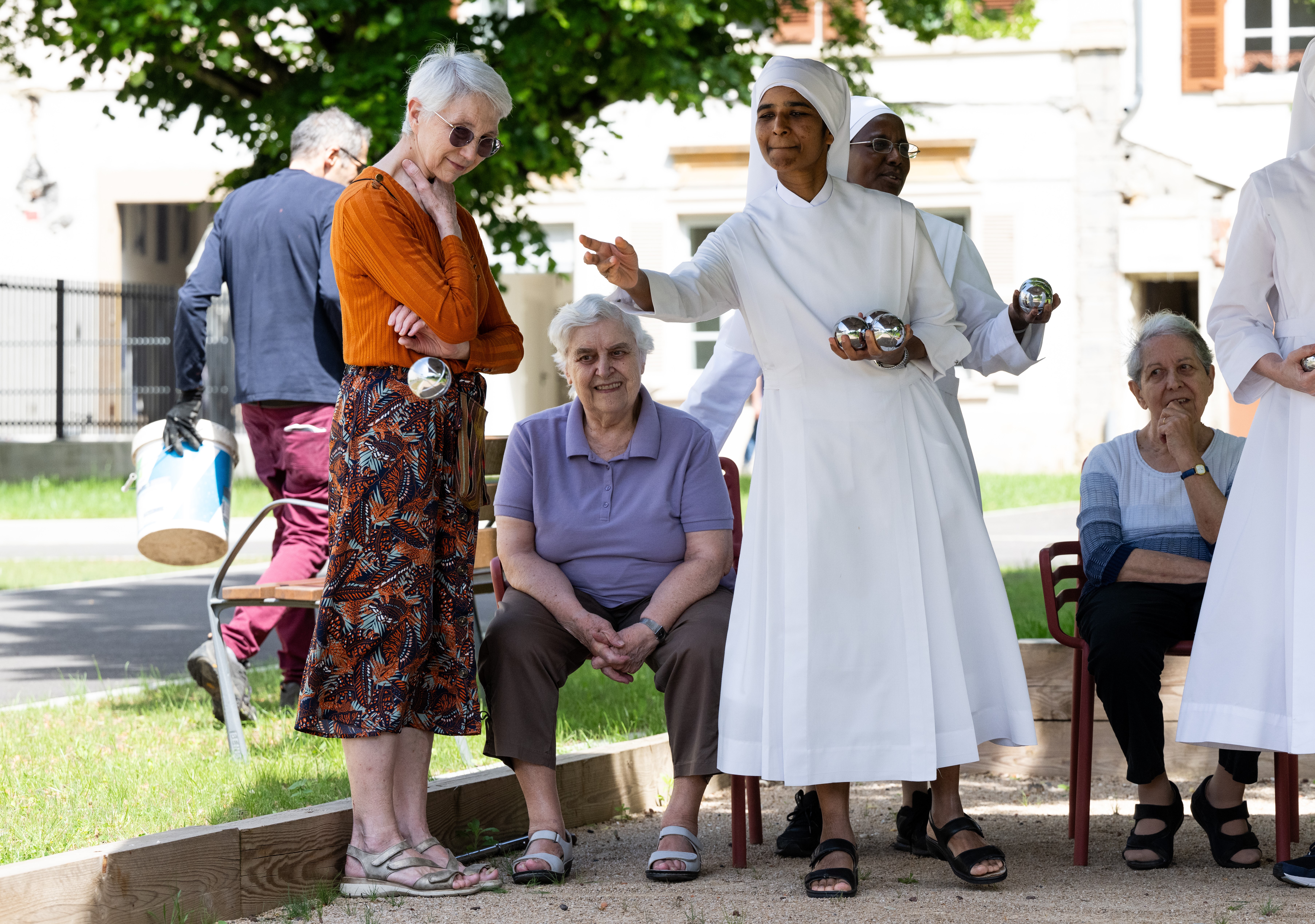 Personnes âgées et petite soeurs qui jouent à la pétanque