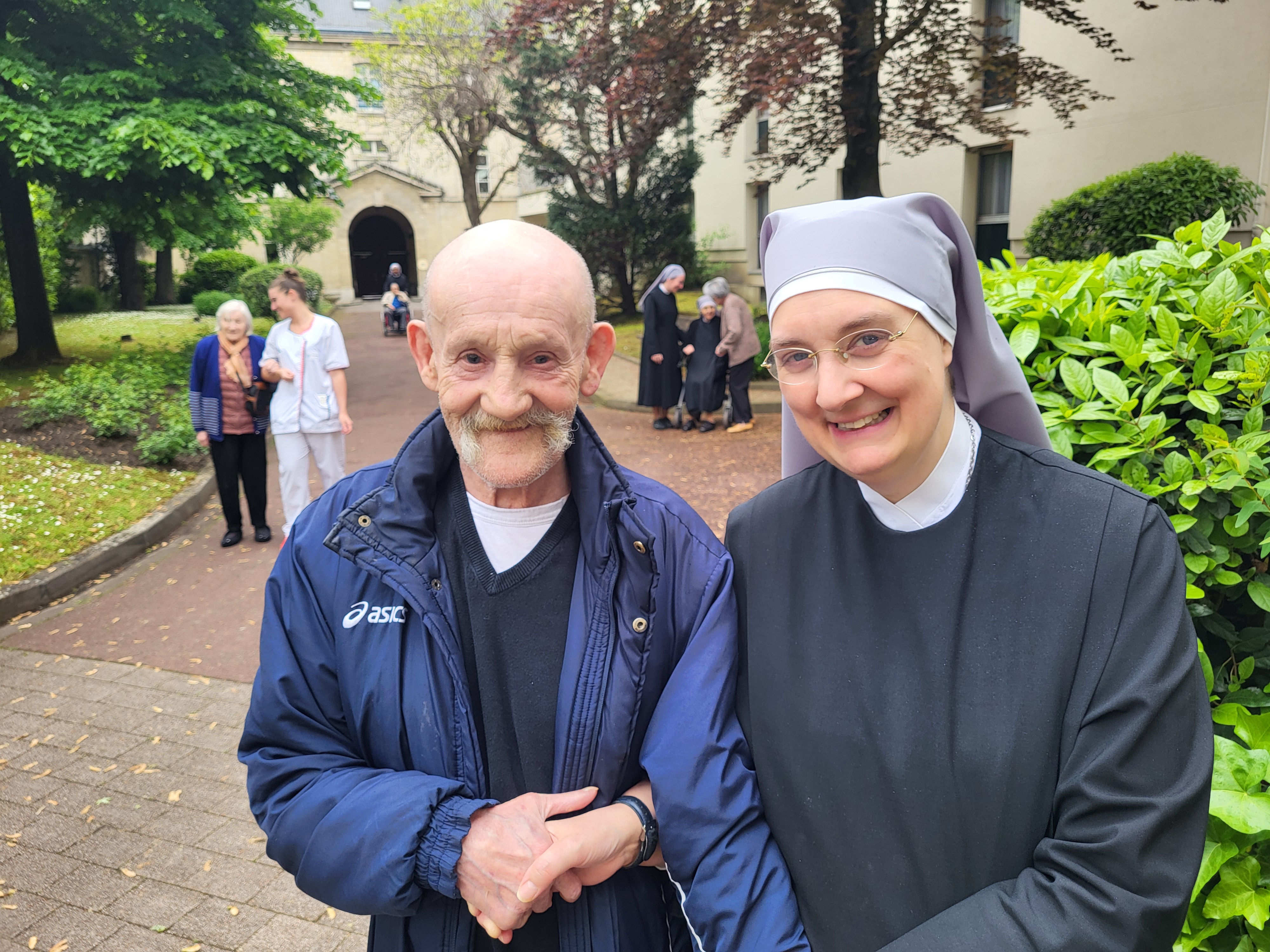 Personne âgée et petite soeur qui se promènent dans un jardin