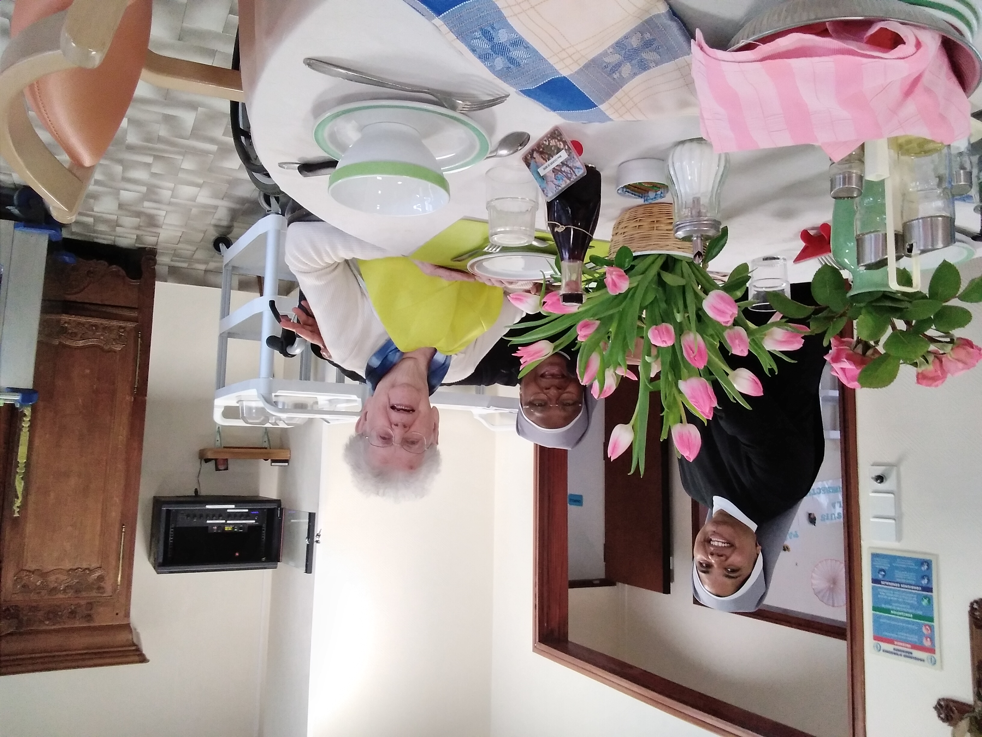 Anniversaire d'une personne âgée dans une grande salle avec un gâteau et le maire