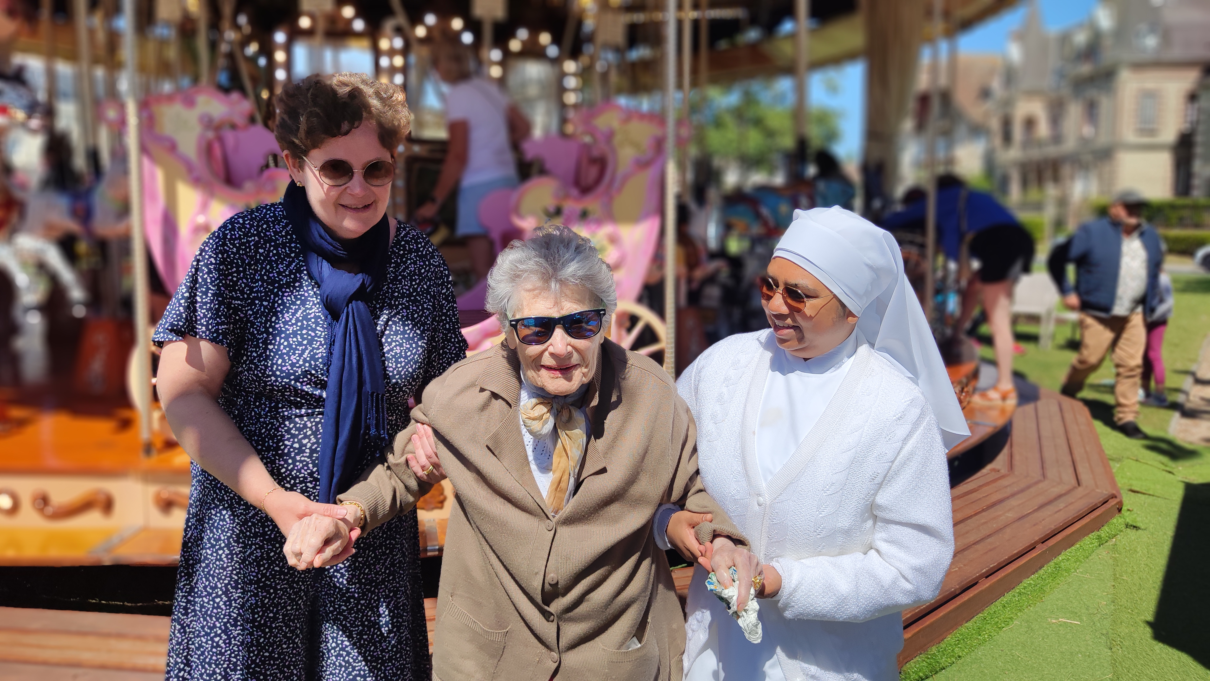 Personnes âgées et une petite soeur devant un manège