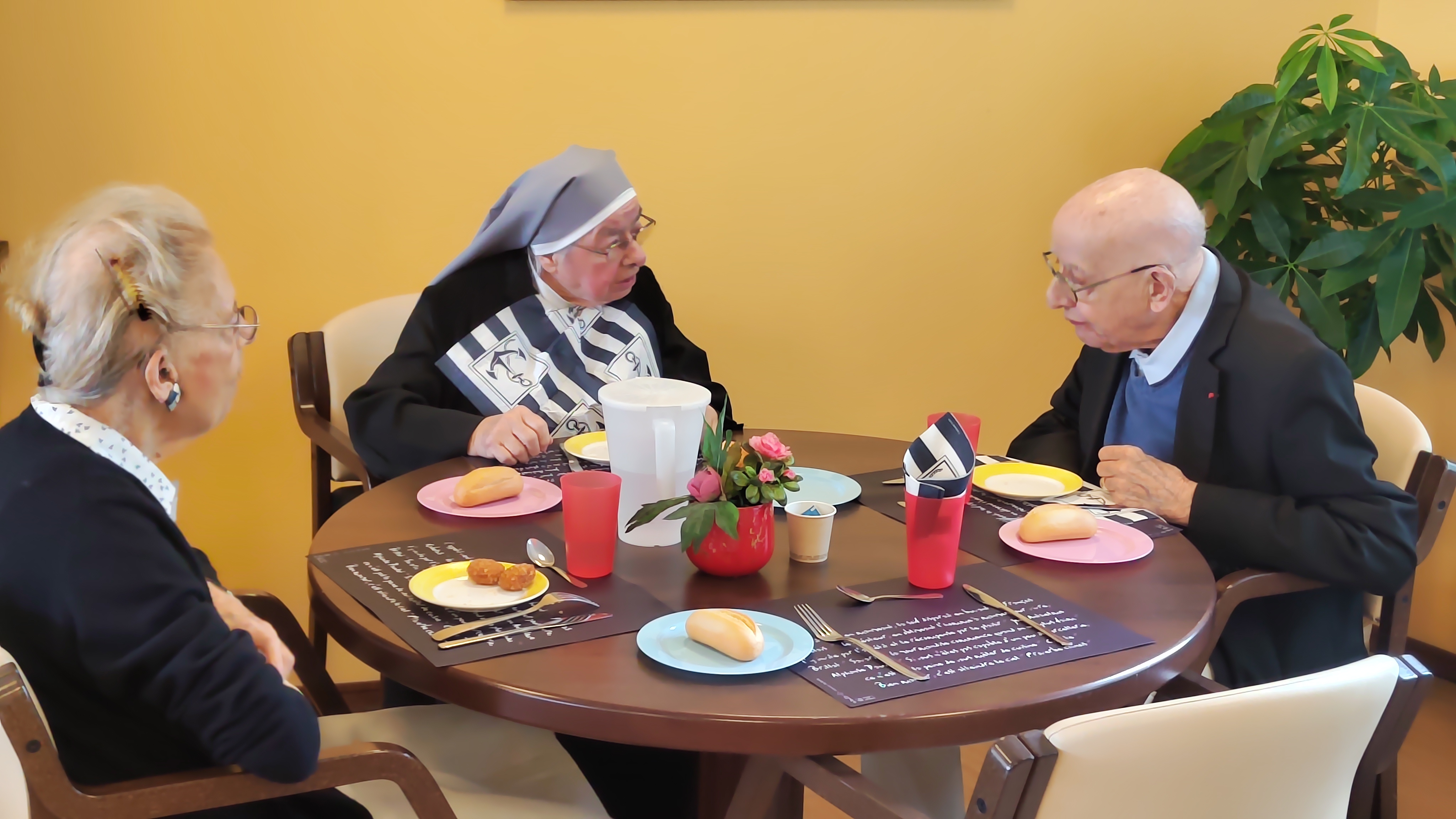 Personnes âgées et une petite soeurs qui prennent leur petite déjeuner