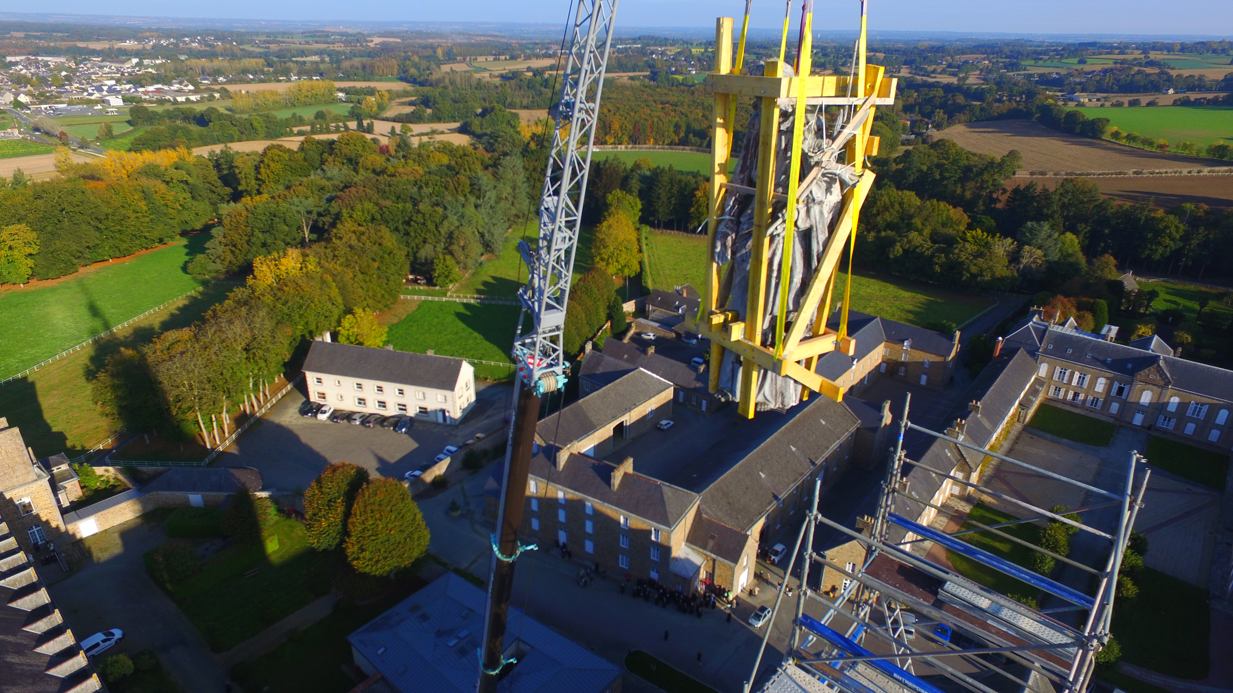 Grande statue de Saint Joseph qui descend d'un échafaudage avec une grue