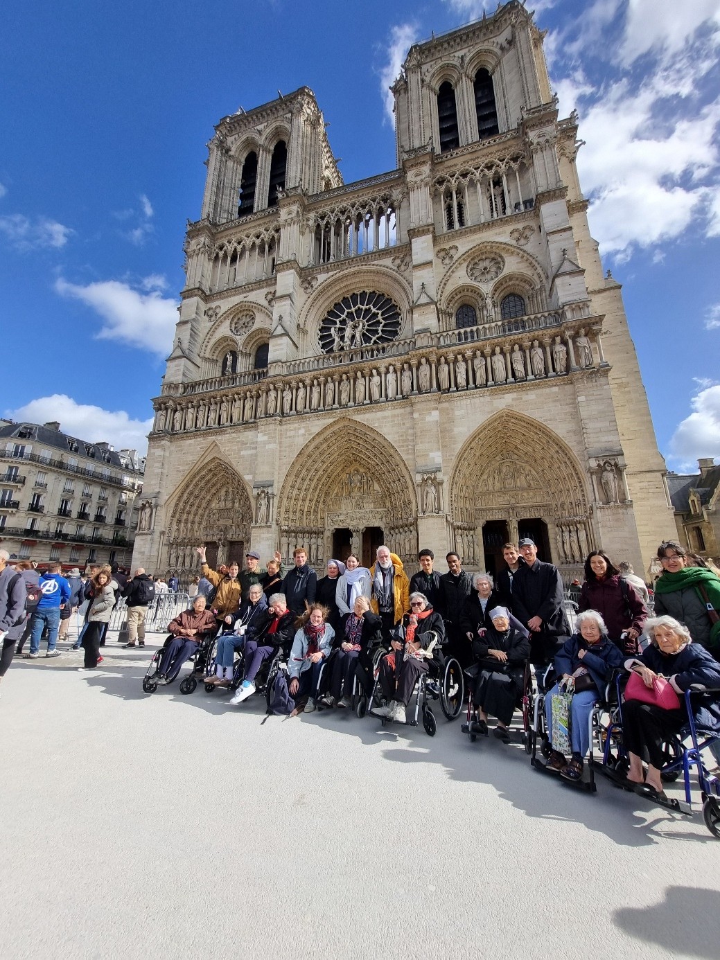 Personnes âgées avec des jeunes et des petites sœurs devant Notre Dame de Paris