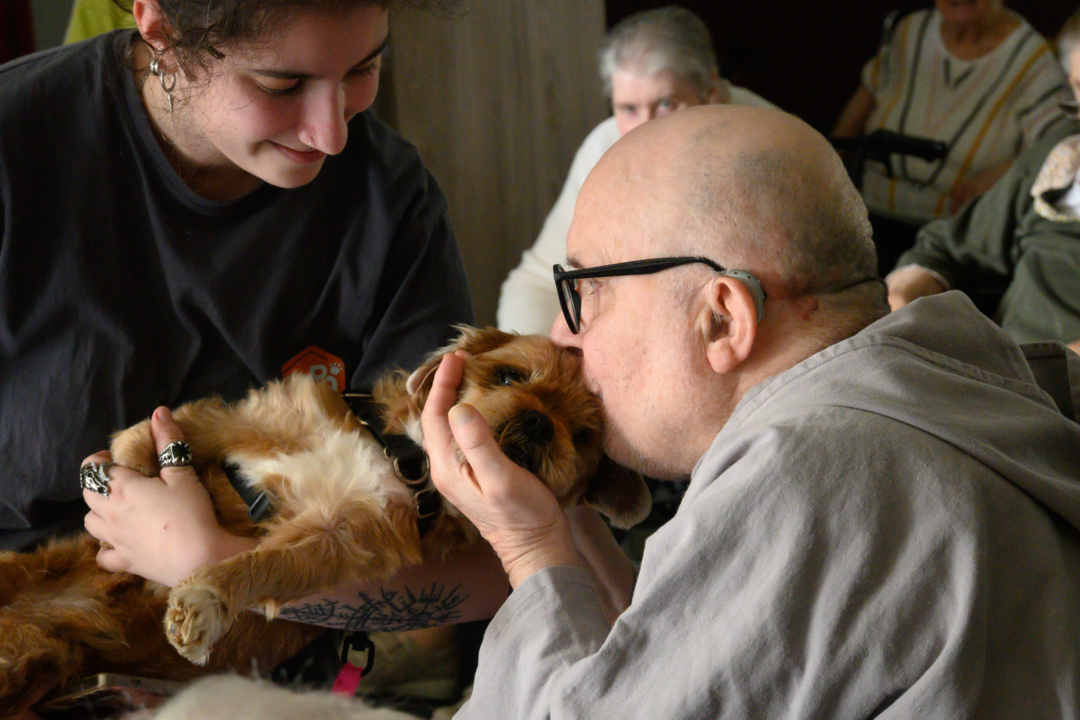 Personne âgé qui fait un bisous à un chien