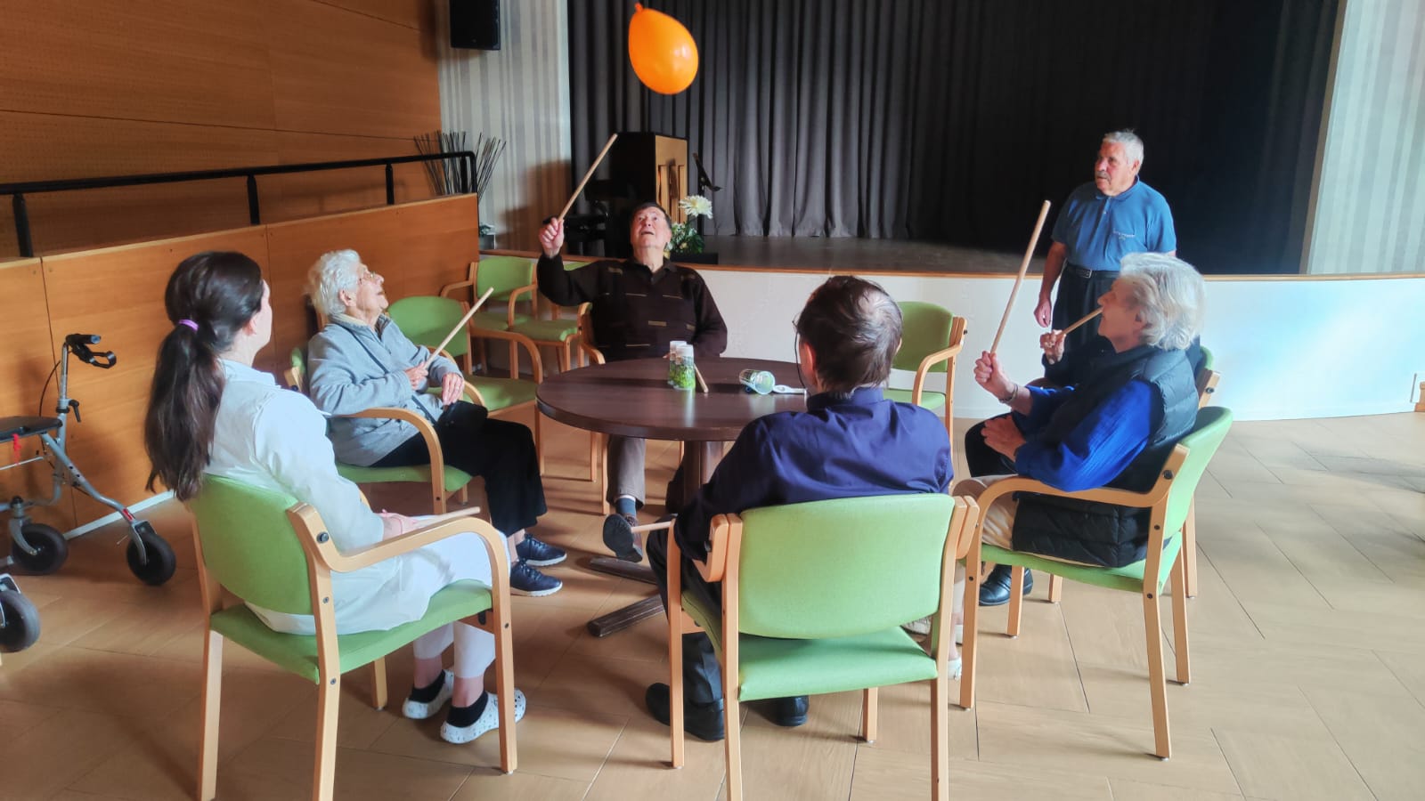 Personnes âgées assis autour d'une table qui font de la gym douce