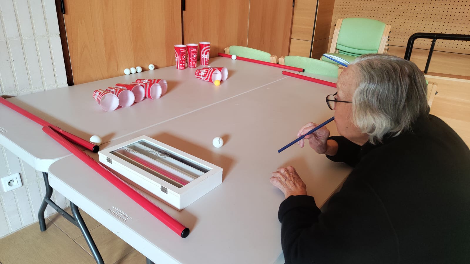 Personne âgée qui souffle dans une paille