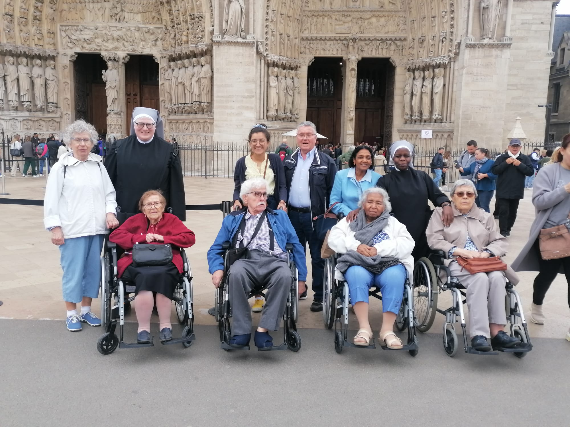 Personnes âgées et petites sœurs devant Notre Dame de Paris
